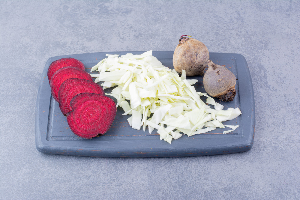 Przygotowane pokrojone buraki i poszatkowana kapusta na desce