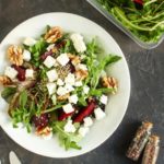 Sałatka z buraków, fety i orzechów włoskich z rukolą na białym talerzu