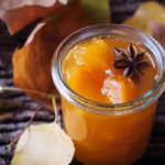 Słoiczek z konfiturą z dyni i pomarańczy na drewnianym stole z gwiazdką anyżu